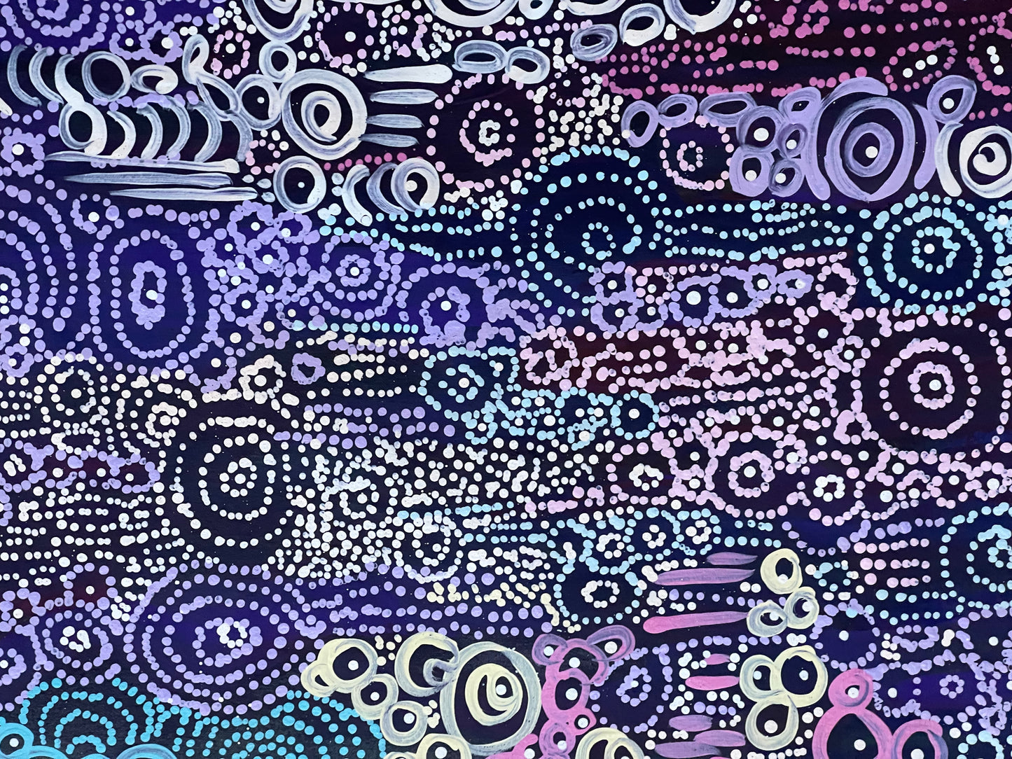 A close-up of Meredith Curley's artwork featuring a pattern of swirling circles in various shades of blue, purple, and white on a black background.