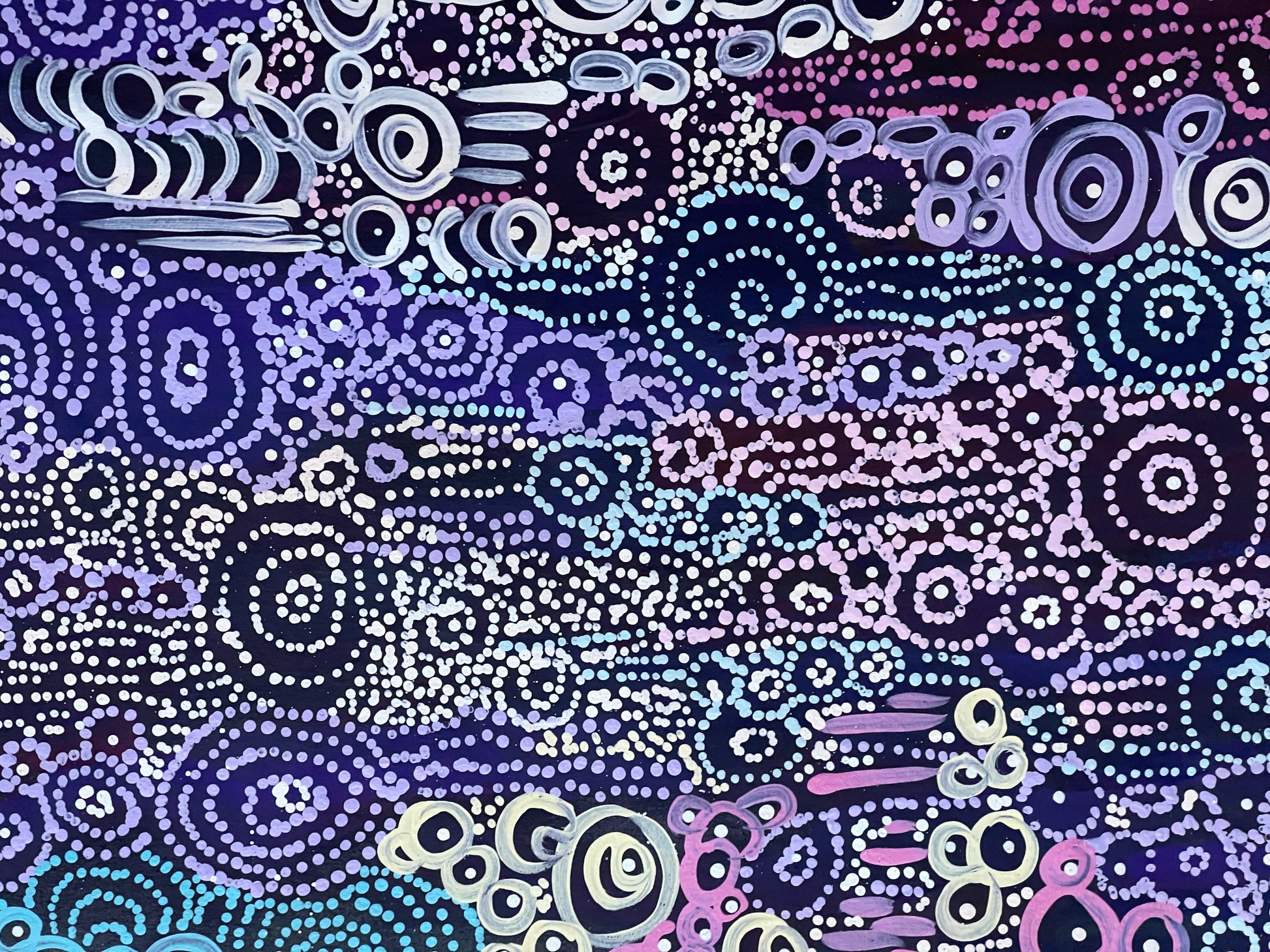 A close-up of Meredith Curley's artwork featuring a pattern of swirling circles in various shades of blue, purple, and white on a black background.