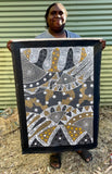 Alvira Bird Mpetyane holding her 'Awelye for Bush Plum, Rat-tail Plant and Mulga Seed' painting 60x90cm