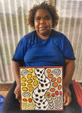 Daphne Larry Nampitjinpa holding her 'My Country' painting 30x30cm