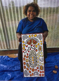 Daphne Larry Nampitjinpa holding her 'My Country' painting 30x60cm