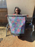 Eileen Bird Kngwarreye holding her 'Arlatyeye (Pencil Yam) Dreaming' painting 60x60cm Multi