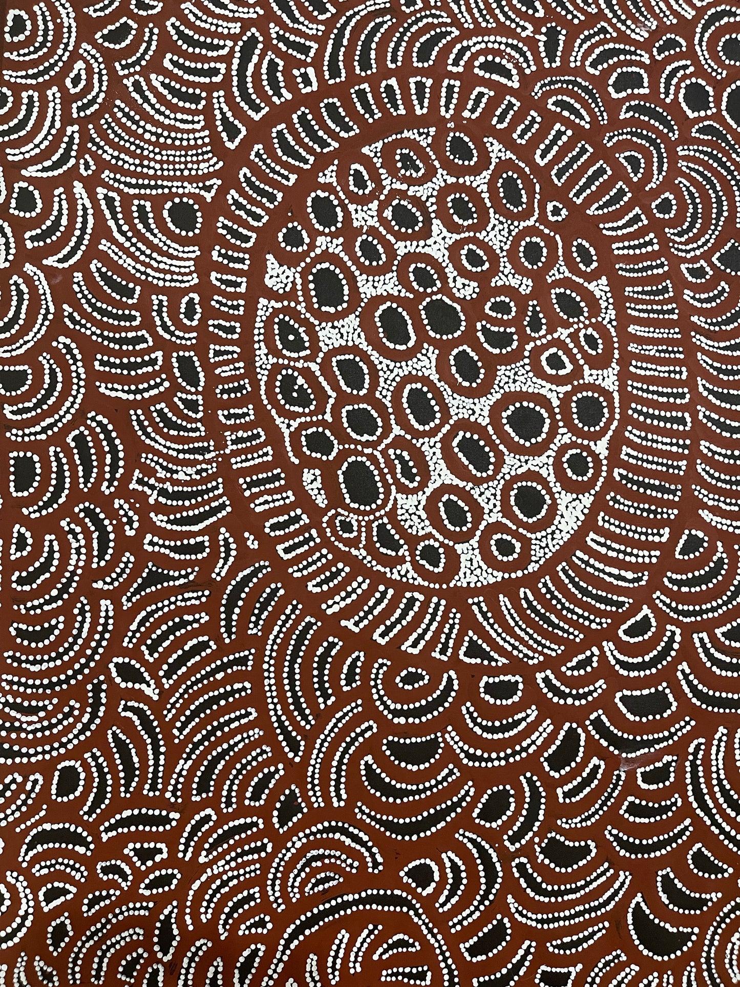 A close-up image of a painting by Tjawina Porter Nampitjinpa in maroon, white and black colours.