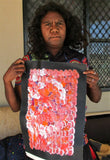 Belinda Golder Kngwarreye holding her Bush Plum Dreaming painting Orange White