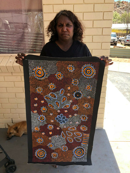 Freda Price Pitjara holding her 'My Country' painting 100x50cm