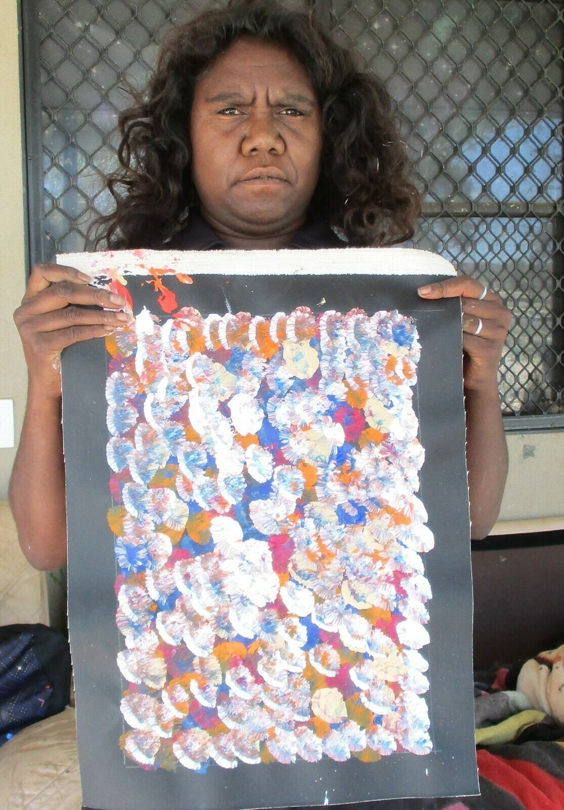 Belinda Golder Kngwarreye holding her Bush Plum Dreaming painting
