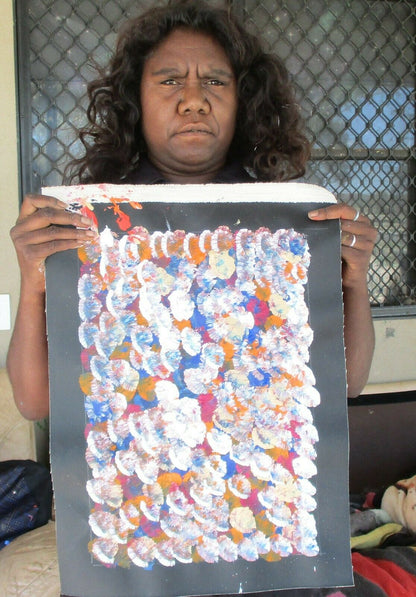 Belinda Golder Kngwarreye holding her Bush Plum Dreaming painting