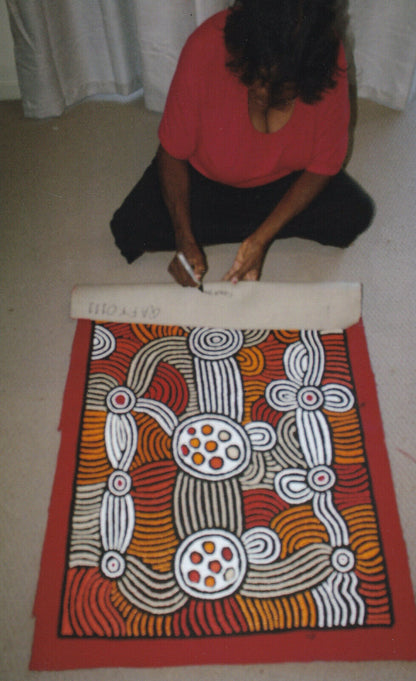 Fiona Young Napanangka signing her 'My Country' painting 95x61cm