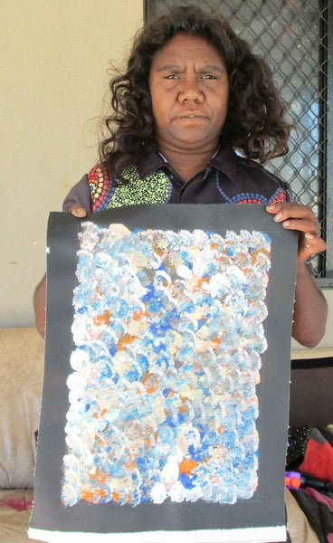 Belinda Golder Kngwarreye holding her Bush Plum Dreaming painting