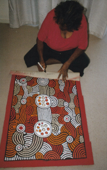 Fiona Young Napanangka signing her 'My Country' painting 95x61cm