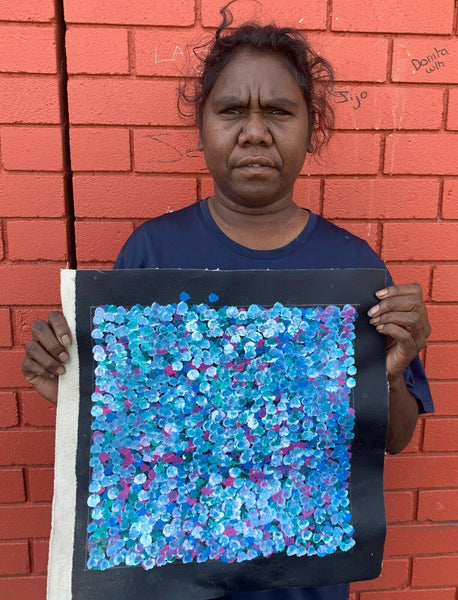 Belinda Golder Kngwarreye Bush holding her 30x30cm Plum Dreaming painting Blue Green Pink White