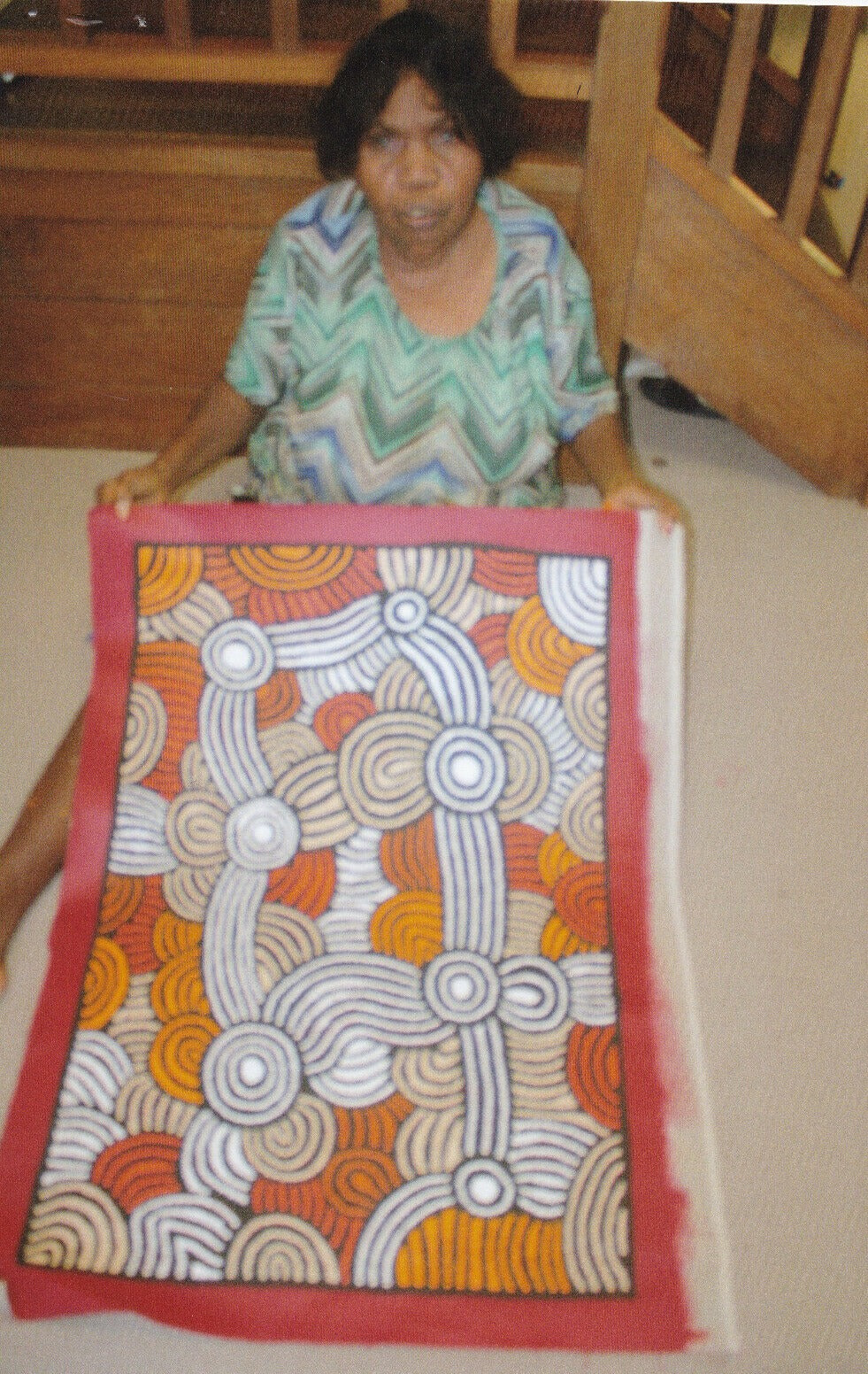 Fiona Young Napanangka holding her 'My Country' painting 89x61cm