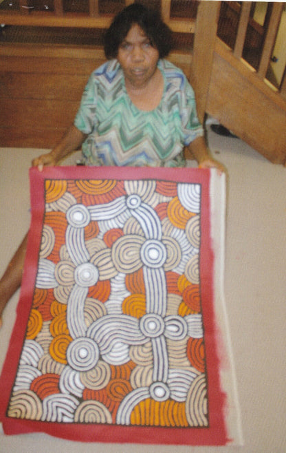 Fiona Young Napanangka holding her 'My Country' painting 89x61cm