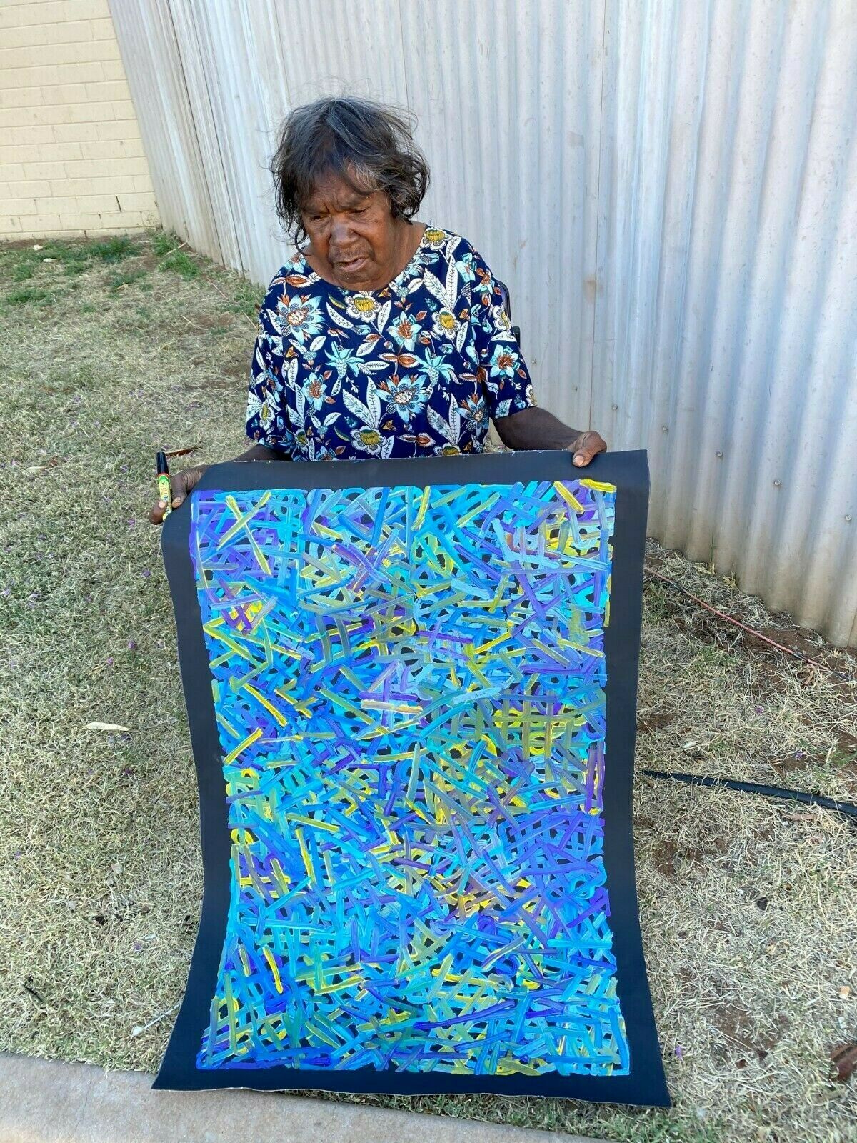 Betty Club Mbitjana holding her My Mother's Dreaming painting 60x90cm 