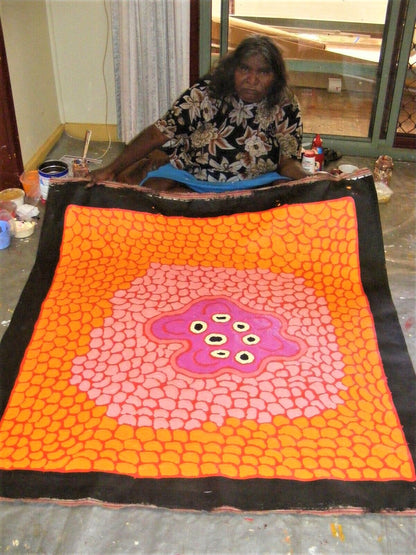 Barbara Reid Napangardi holding Women's Waterhole  Orange Red Pink