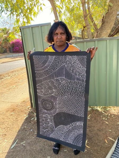 Freda Price Pitjara holding her 'My Country' painting 100x50cm Black and White