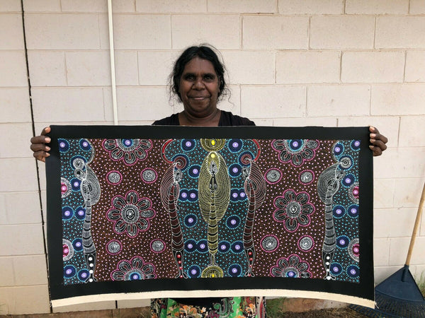 Colleen Wallace Nungarrayi holding her 'Dreamtime Sisters' painting 44x89cm