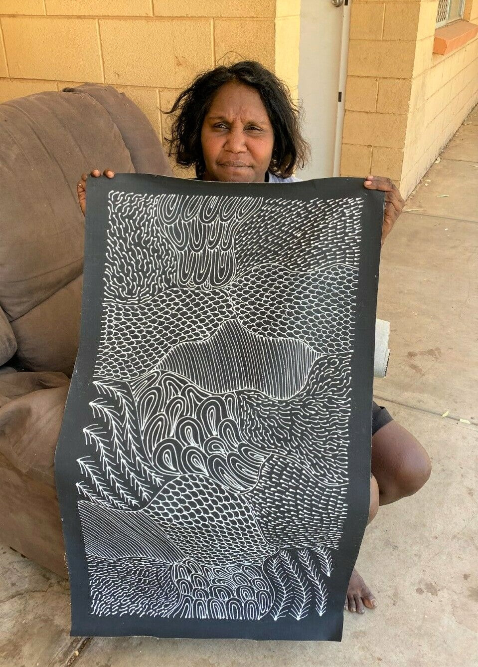 Freda Price Pitjara holding her 'My Country' painting 100x50cm Black and White