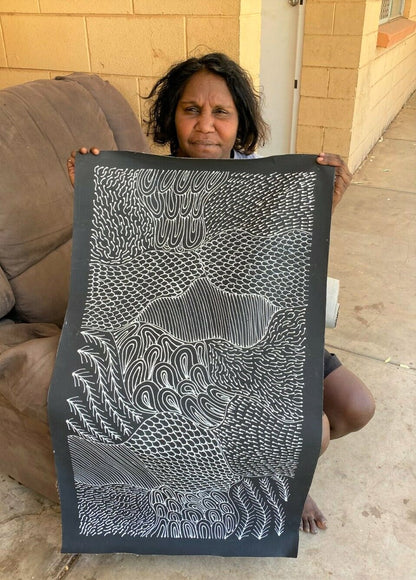 Freda Price Pitjara holding her 'My Country' painting 100x50cm Black and White