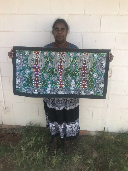 Colleen Wallace Nungarrayi holding her 'Dreamtime Sisters' painting 45x90cm