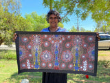 Colleen Wallace Nungarrayi holding her 'Dreamtime Sisters' painting 45x90cm