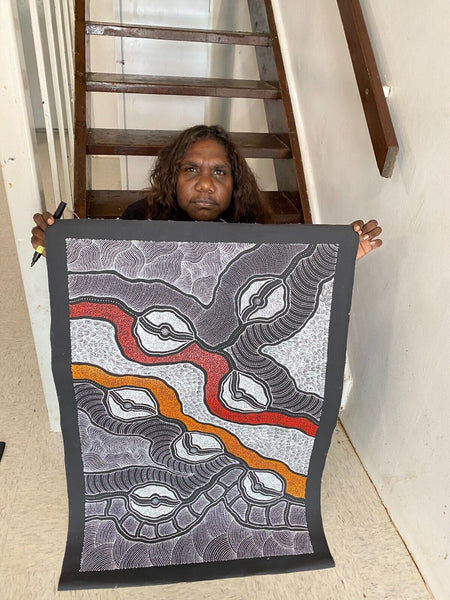 Delvine Pitjara holding her 'My Country' painting 90x60cm White Black Red Orange