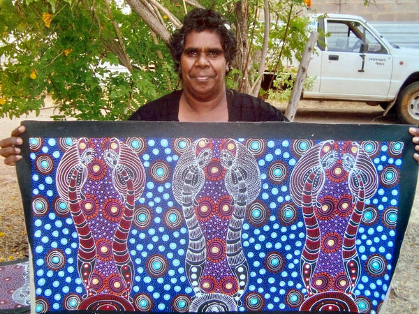 Colleen Wallace Nungarrayi holding her 'Dreamtime Sisters' painting 45x90cm