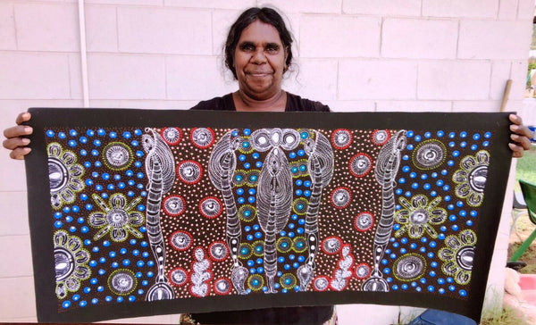 Colleen Wallace Nungarrayi holding her 'Dreamtime Sisters' painting 44x100cm