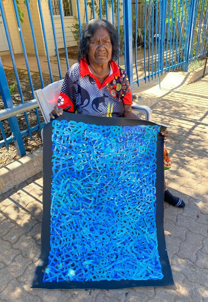 Betty Club Mbitjana 90x60cm holding her painting.
