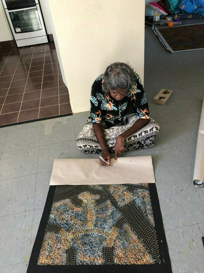 Gracie Morton Pwerle signing her 'Bush Plum Dreaming' painting 90x60cm