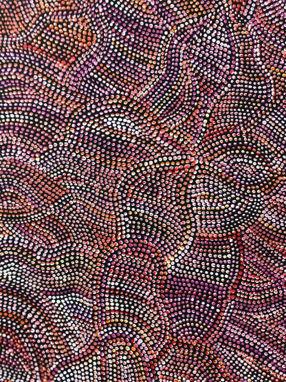 A close-up of an acrylic painting on primed linen by Joy Purvis Pitjara, featuring a detailed pattern of Bush Yam seeds with a mix of red, pink, and white dots on a black background